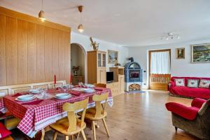 a kitchen and living room with a table and chairs at Casa Magda in Tesero