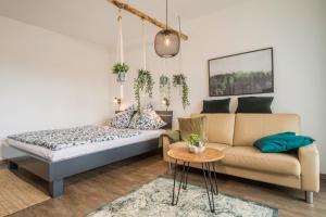 a living room with a bed and a couch at Heimelig im Hirschen App 240 in Schönwald +19 photos