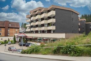 a building with a parking lot in front of it at Heimelig im Hirschen App 240 in Schönwald