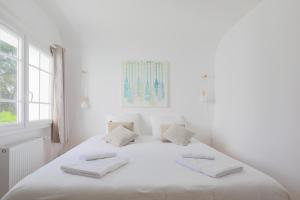 a white bedroom with a large bed with white sheets at Ker Lotig in Locquirec