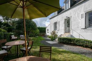 a table and chairs with an umbrella in a yard at Ker Lotig in Locquirec