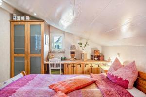 a bedroom with a bed with pink pillows at Eifelyeti Ferienwohnung mit Sauna in Ellscheid
