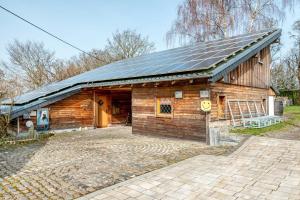a wooden barn with solar panels on the roof at Eifelyeti Ferienwohnung mit Sauna in Ellscheid