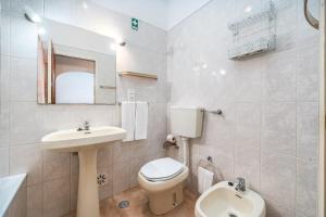 a white bathroom with a toilet and a sink at Candirocha A8 in Portimão