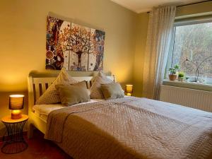 a bedroom with a bed with a painting on the wall at Ferienwohnung an der Schlei in Fleckeby