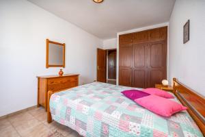 a bedroom with a bed with pink pillows on it at Candirocha A8 in Portimão