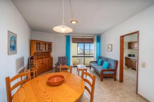 a living room with a table and a couch at Candirocha A8 in Portimão +13 photos