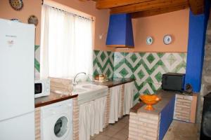 a kitchen with a sink and a washing machine at Casa Jara in Azuara