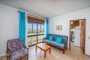 a living room with a couch and a chair at Candirocha A8 in Portimão