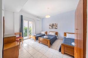a bedroom with two beds and a living room at Roys Blu in Kavos