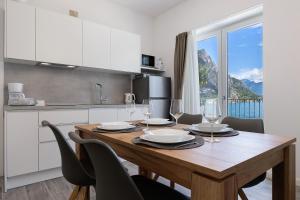 a kitchen with a wooden table with wine glasses at Jacky's Apartments in Limone sul Garda