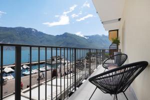 a balcony with two chairs and a view of the water at Jacky's Apartments in Limone sul Garda