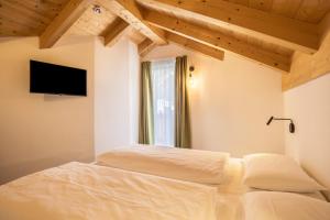 a bedroom with two beds and a flat screen tv at Apartment Sis Residence Bun Ste in San Vigilio Di Marebbe