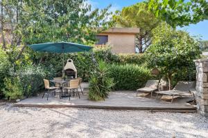 a patio with a table and chairs and an umbrella at Villa Nui in Cuers