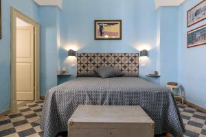 a bedroom with a bed and a blue wall at Donna Cesarina - Maison de Charme in Maruggio
