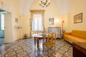 a living room with a table and a couch at Donna Cesarina - Maison de Charme in Maruggio