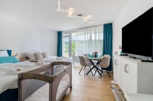 a living room with two beds and a flat screen tv at Ferienwohnung Mainaublick in Uhldingen-Mühlhofen