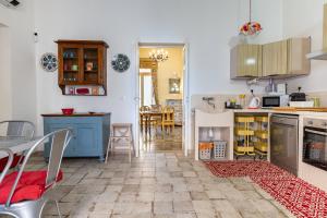 a kitchen and dining room with a table and chairs at Donna Cesarina - Maison de Charme in Maruggio +20 photos