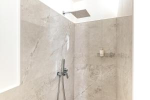 a bathroom with a shower with marble walls at Donna Cesarina - Maison de Charme in Maruggio