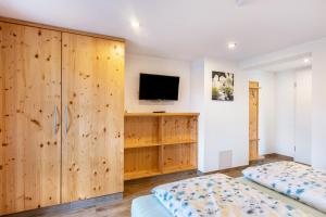 a bedroom with wooden cabinets and a tv at Das Schwarzwälder Speckhuisli in Grafenhausen