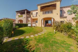 a large house with a lawn in front of it at Villetta Giardino e Piscina in Porto San Paolo
