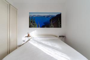 a bed in a white room with a picture on the wall at La Castellana in Gallipoli