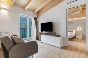 a living room with a couch and a tv and a bed at Jacky's Apartments in Limone sul Garda