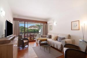 a living room with a couch and a tv at Tenis Golfmar in Vilamoura