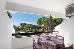 a balcony with a table and chairs and a large window at Tenis Golfmar in Vilamoura