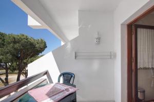a room with a table and a chair on a balcony at Tenis Golfmar in Vilamoura