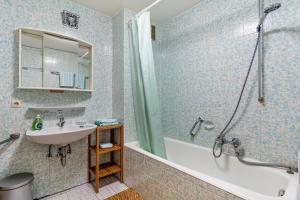 a blue tiled bathroom with a sink and a shower at Ferienwohnung Frechehof 74qm in Bad Peterstal +14 photos