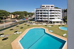 an overhead view of a swimming pool in front of a building at Tenis Golfmar in Vilamoura