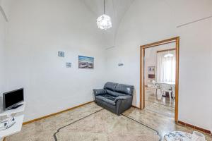 a living room with a leather chair and a television at Cod 278 al centro del paese in Ugento