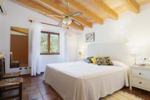 a white bedroom with a bed and a ceiling fan at Llangana in Pollença +12 photos