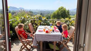 a group of children sitting around a table on a porch at Traumhaus mit herrlichem Graz Blick in Graz