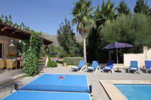 a blue ping pong table and chairs and a pool at Llangana in Pollença