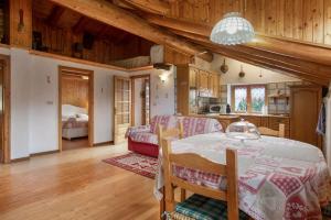 a kitchen and living room with a table and a couch at Piccolo Paradiso in Cogne