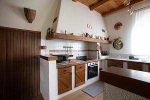 a kitchen with wooden cabinets and a stove at La Ginestra Appartamenti e Camere in Mossa +91 photos