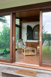 a screened in porch with glass doors and chairs at La Ginestra Appartamenti e Camere in Mossa
