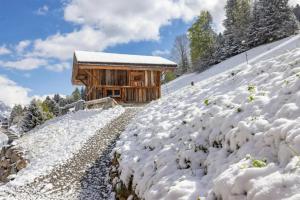 a cabin covered in snow on a snowy hill at Mazot de Warens in Combloux
