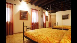 a bedroom with two beds and two windows at Gorgeous 1 double bedroom apartment in Bellagio