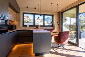 a kitchen with a table and chairs and windows at Levita Living Freiheit in Tirolo +35 photos