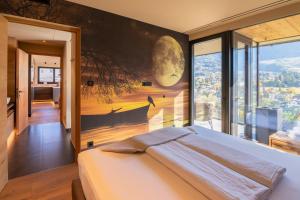 a bedroom with a bed and a large window at Levita Living Freiheit in Tirolo