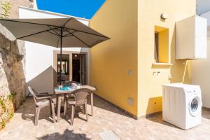a table and chairs with an umbrella on a patio at Casa Incanto in Presicce