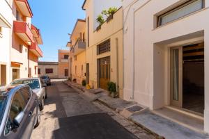 a narrow street with cars parked in front of buildings at Casa Incanto in Presicce