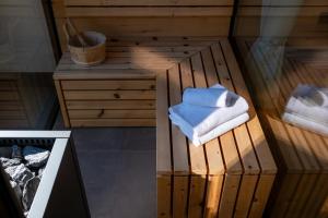 a sauna with a stack of towels on a wooden platform at Levita Living Freiheit in Tirolo