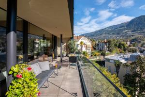 a balcony with chairs and a view of a city at Levita Living Freiheit in Tirolo