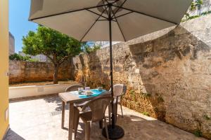 a table with an umbrella on a patio at Casa Incanto in Presicce +17 photos