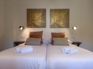 two beds in a room with white sheets and towels at Villa Arbona Dalt in Sóller