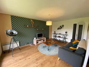 a living room with a couch and a table at Le Lodge d Angèle in Honfleur